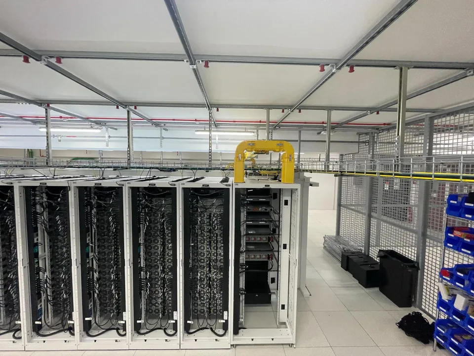 Vue d’une salle de datacenter avec plusieurs baies informatiques.